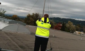 Technicien vérifiant un paratonnerre sur une toiture